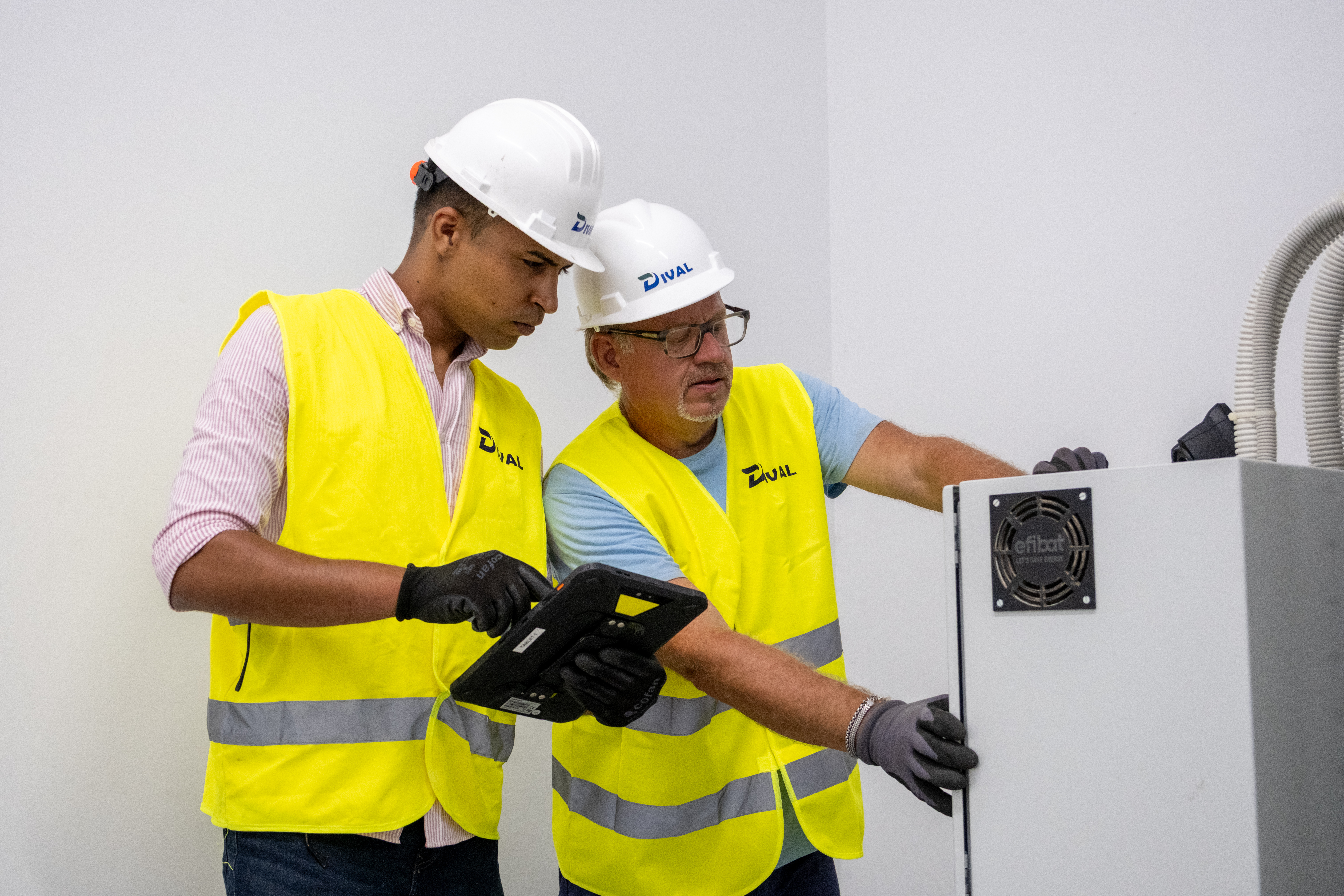 Dos profesionales de Dival Technology realizando trabajos de mantenimiento eléctrico
